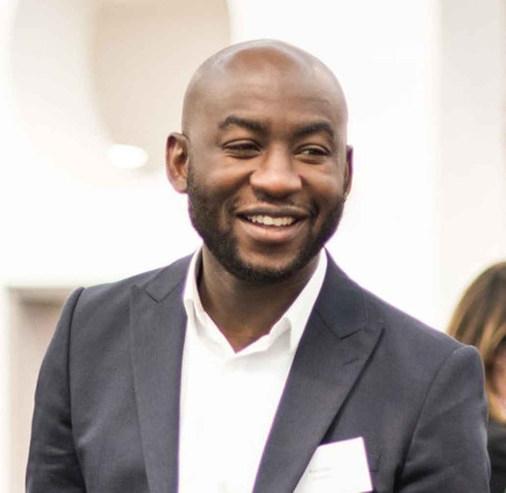 Photo of Poku taken during the panel, he is smiling in conversation